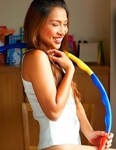 Sexy girl Koko Tongpu has on panties with a shirt. She has a hula hoop around her waist and she shows you how to work it.