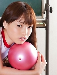Maho Kiruma in sports equipment plays with ball on desk