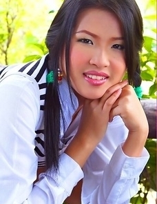 Aime Copony begins posing and she smiles for the camera while wearing a white and black top.