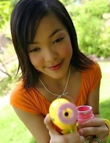 Mizuno Manabe has on an orange top with yellow panties. She struts around the room playing with a bubble blower.