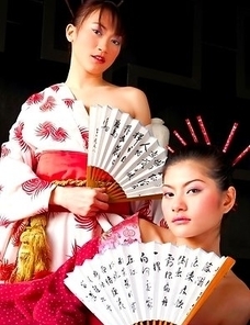 Mona Choi and Mind Sumonrat are dressed up as royalty as they hold their fans in their hands.