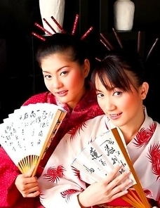 Mona Choi and Mind Sumonrat are dressed up as royalty as they hold their fans in their hands.